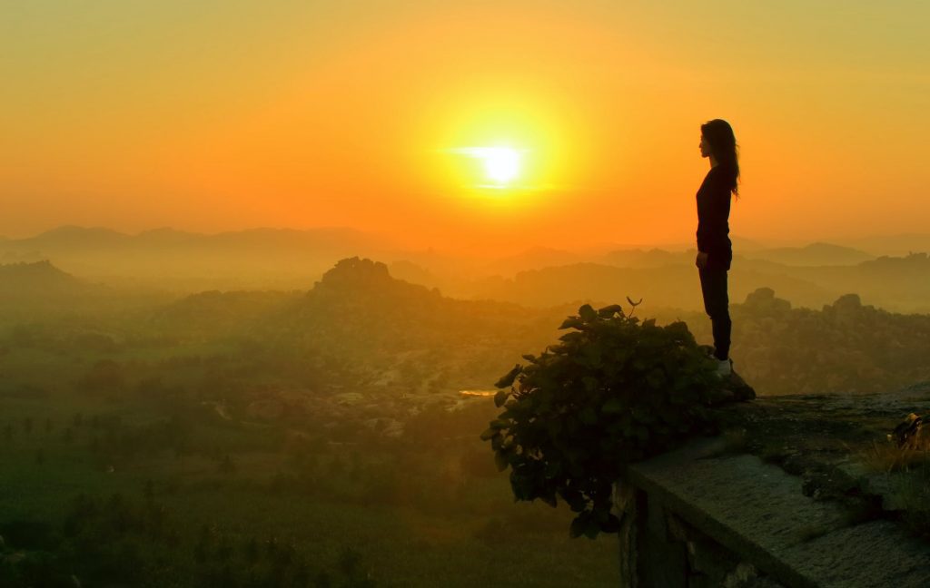 silhouette of woman standing near cliff